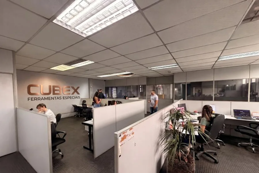Escritório da CUBEX com equipe trabalhando e o letreiro CUBEX Ferramentas Especiais na parede.